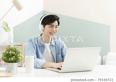 Asian handsome young man with headset, using laptop Asian handsome young man with headset, using laptop 79330721