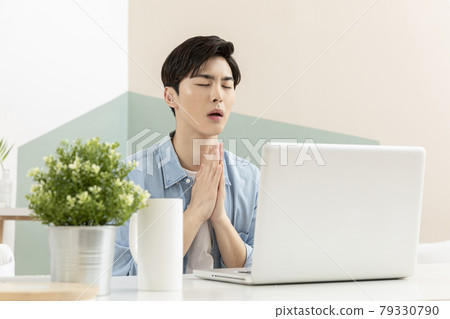 handsome young Asian job seeker checking result through laptop handsome young Asian job seeker checking result through laptop 79330790