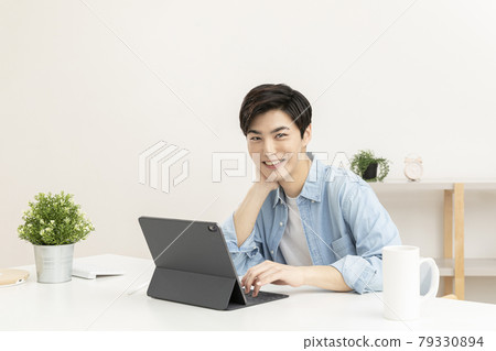 Asian young man using tablet device 79330894