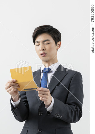 Asian man employee checking his balance in bank book Asian man employee checking his balance in bank book 79330896