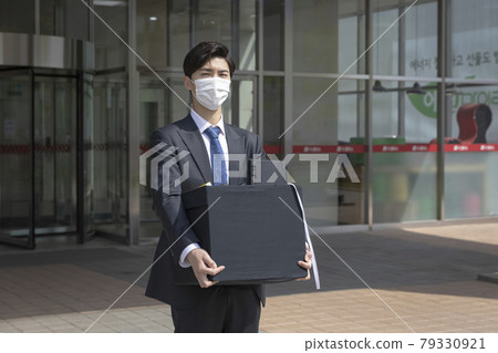 Asian man employee with mask leaving office with box due to lay off, covid 19 effects in business Asian man employee with mask leaving office with box due to lay off, covid 19 effects in business 79330921