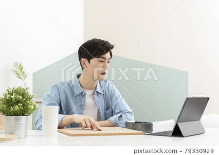 Asian young man learning chess through online class using tablet device Asian young man learning chess through online class using tablet device 79330929