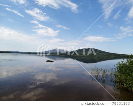 Mountains and the sky are reflected in a lake 79331163
