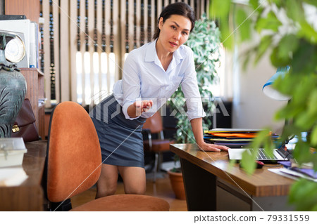 Friendly female office employee making inviting gesture Friendly female office employee making inviting gesture 79331559