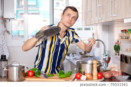 Ordinary man cooking soup in kitchen 79331561