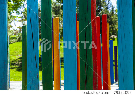 Multicolored wooden poles in a summer park Multicolored wooden poles in a summer park 79333095