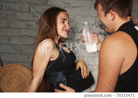 young caucasian couple together having fun on kitchen, woman pregnant, drinking milk, lifestyle people concept young caucasian couple together having fun on kitchen, woman pregnant, drinking milk, lifestyle people concept 79333471