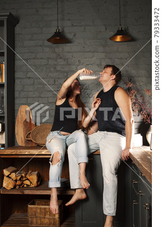 young caucasian couple together having fun on kitchen, woman pregnant, drinking milk, lifestyle people concept 79333472