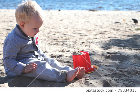Cute baby boy playing with beach toys on tropical beach Cute baby boy playing with beach toys on tropical beach 79334015