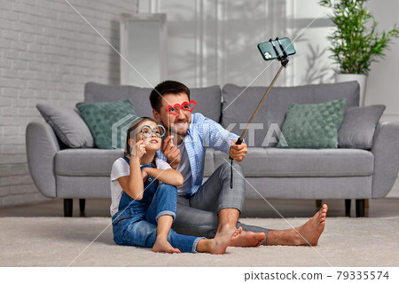 father and child holding paper glasses on stick and take a selfie father and child holding paper glasses on stick and take a selfie 79335574