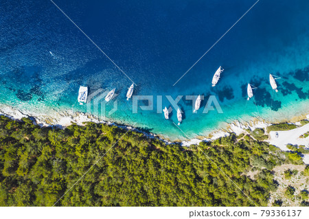Top down aerial view of sailing boats docked in blue bay of Fiskardo, Kefalonia island, Ionian, Greece Top down aerial view of sailing boats docked in blue bay of Fiskardo, Kefalonia island, Ionian, Greece 79336137