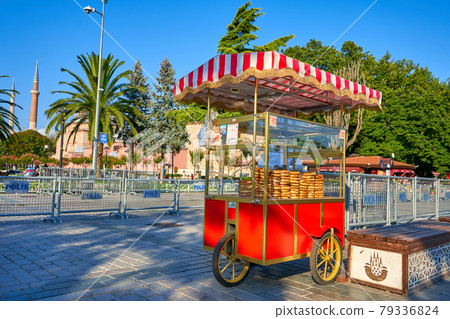 Man sale traditional Turkish bagel simit from cart on the summer Istanbul street Man sale traditional Turkish bagel simit from cart on the summer Istanbul street 79336824