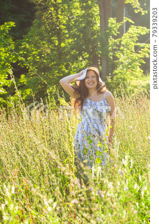 Woman walking in a field in summer sunny day. 79339203