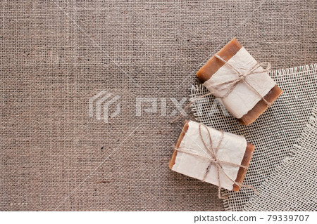 Top view on handmade natural soap bars or dry shampoo with on rustic fabric background with copy space. Close up of home spa products made with natural ingridients and organic essential oils Top view on handmade natural soap bars or dry shampoo with on rustic fabric background with copy space. Close up of home spa products made with natural ingridients and organic essential oils 79339707