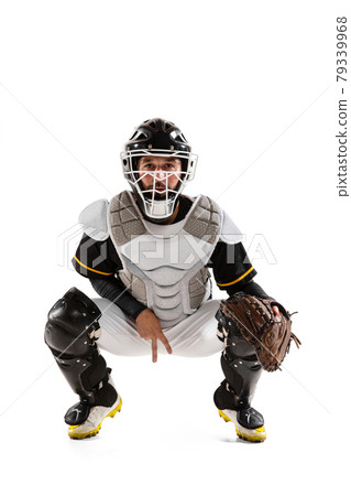 Baseball player, catcher in white sports uniform and equipment practicing isolated on a white studio background. Baseball player, catcher in white sports uniform and equipment practicing isolated on a white studio background. 79339968