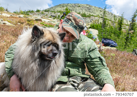 Man hugs his beloved dog while walking in the mountains Man hugs his beloved dog while walking in the mountains 79340707