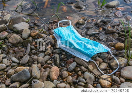 Used medical mask discarded by the river 79340708