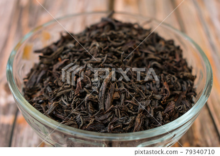 Dry large black tea leaves in a glass bowl Dry large black tea leaves in a glass bowl 79340710