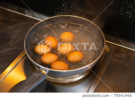 Boiling chicken eggs in metal pan with high heat on electric stove in the kitchen. Cooking method. Food Boiling chicken eggs in metal pan with high heat on electric stove in the kitchen. Cooking method. Food 79341468