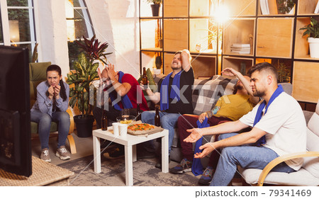 Young men watching TV, sport match together. Concept of friendship, leisure activity, emotions Young men watching TV, sport match together. Concept of friendship, leisure activity, emotions 79341469