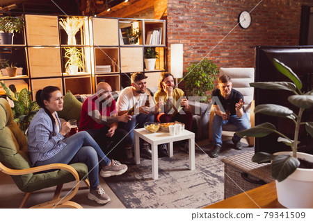 Group of friends watching TV, sport match together. Concept of friendship, leisure activity, emotions Group of friends watching TV, sport match together. Concept of friendship, leisure activity, emotions 79341509