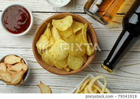 Different snacks, beer and sauces on white wooden background Different snacks, beer and sauces on white wooden background 79341919