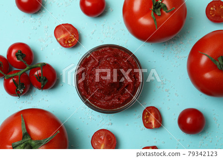 Bowl with tomato paste, tomatoes and salt on blue background Bowl with tomato paste, tomatoes and salt on blue background 79342123