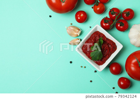 Bowl of tomato paste and ingredients on mint background Bowl of tomato paste and ingredients on mint background 79342124