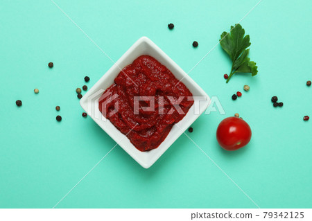 Bowl of tomato paste, peppercorns, parsley and tomato on mint background Bowl of tomato paste, peppercorns, parsley and tomato on mint background 79342125