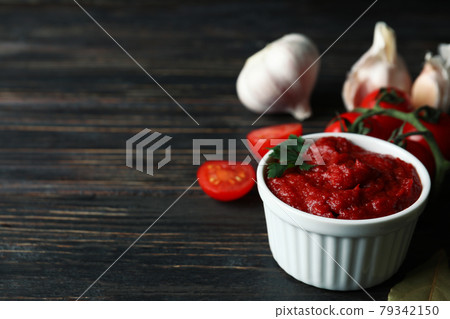 Bowl with tomato paste, tomatoes and garlic on wooden table Bowl with tomato paste, tomatoes and garlic on wooden table 79342150