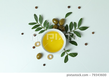 Bowl of oil, olives and twigs on white background Bowl of oil, olives and twigs on white background 79343600