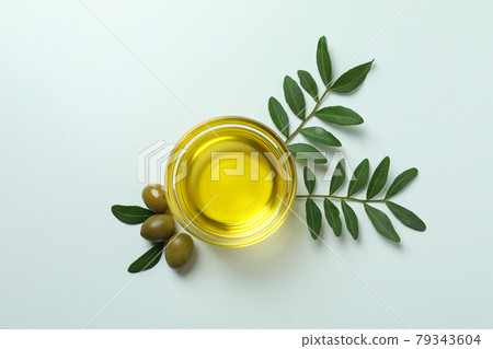Bowl of oil, olives and twigs on white background Bowl of oil, olives and twigs on white background 79343604