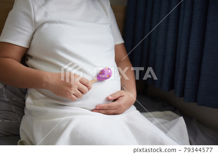 Young Asian Pregnant Woman using rattle toy to play with her unborn baby Young Asian Pregnant Woman using rattle toy to play with her unborn baby 79344577