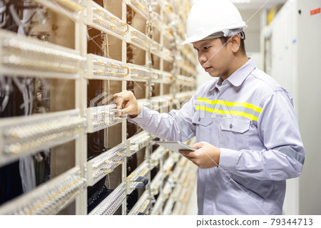 Technician using digital tablet in server room, repair card mainboard checking network link status 79344713