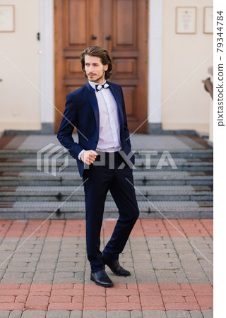 Stylish handsome man with beard, wearing suit jacket and shirt, outdoors on the city street. Stylish handsome man with beard, wearing suit jacket and shirt, outdoors on the city street. 79344784