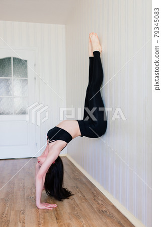 Staying fit and healthy. Beautiful young woman in sports clothing doing yoga while relaxing at home Staying fit and healthy. Beautiful young woman in sports clothing doing yoga while relaxing at home 79345083