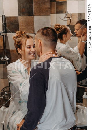 Love, Honeymoon, Romantic, togetherness, tenderness, relationship. Young couple bonding trough morning routine. Happy couple in love brushing teeth in bathroom at home 79345249