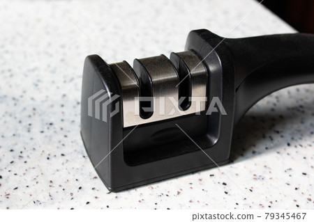 Black knife sharpener on the table closeup 79345467