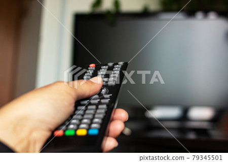 TV remote in hand in the room 79345501