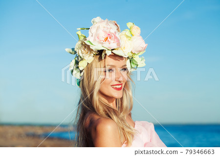 Happy smiling blonde woman with cute smile and long curly hairstyle in sunny day outdoor 79346663