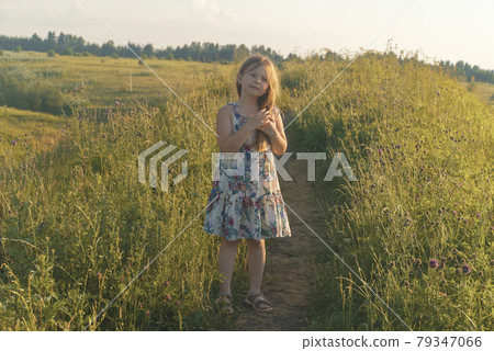 Little girl walks on rural road in summer Little girl walks on rural road in summer 79347066