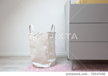Stylish white laundry basket standing in modern room, Modern retro Scandinavian decoration. New Home interior Stylish white laundry basket standing in modern room, Modern retro Scandinavian decoration. New Home interior 79347490