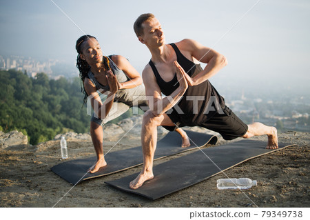 Healthy and strong couple doing yoga exercises outdoors Healthy and strong couple doing yoga exercises outdoors 79349738