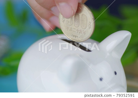 A person who saves money in a piggy bank 79352591