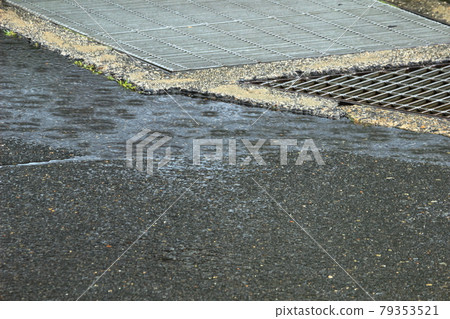 Ripples of raindrops falling on a puddle on the road Ripples of raindrops falling on a puddle on the road 79353521