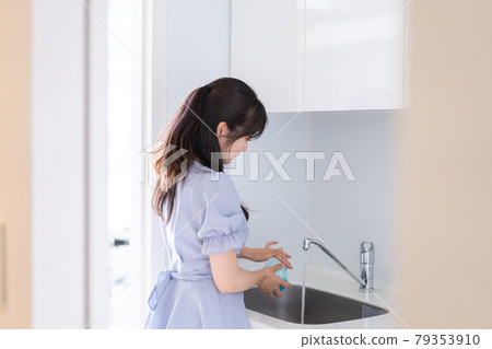 A young woman washing dishes A young woman washing dishes 79353910