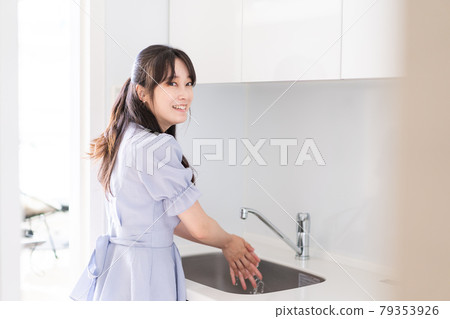 一個年輕的女人洗碗 一個年輕的女人洗碗 79353926