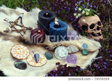 Beltane still life with ritual objects, skull, burning candles, pentagram and crystals outside. Esoteric, gothic and occult background, Halloween mystic and wicca concept.  79356569