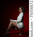 Gorgeous rich blonde woman in long white jacket 79356672