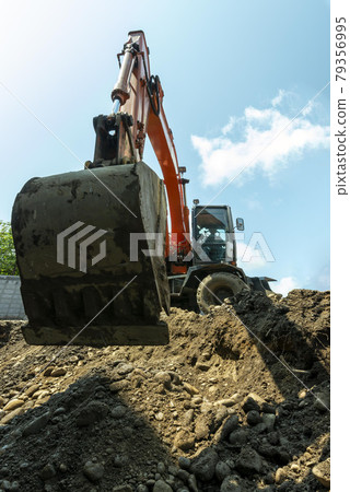 Work to dig a hole at a construction site Work to dig a hole at a construction site 79356995